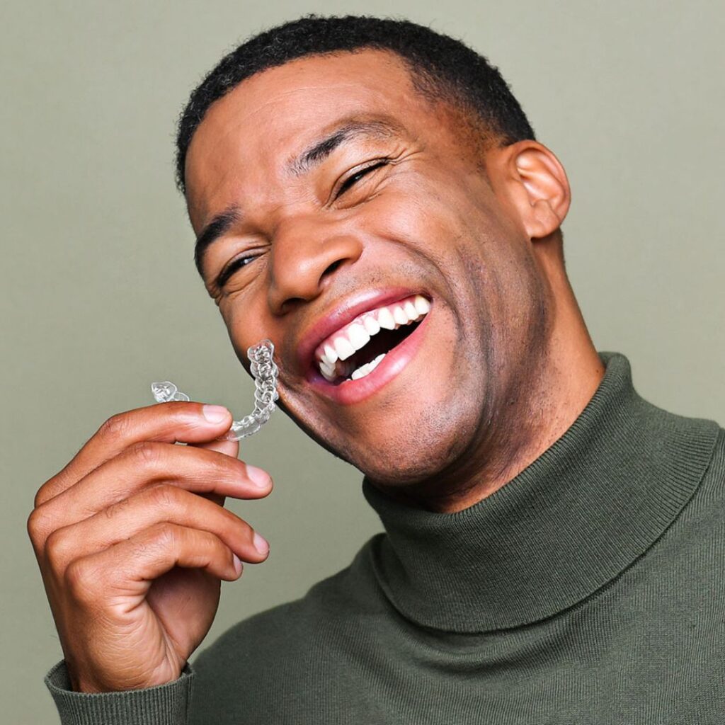 A professional orthodontist in Abuja showing a patient a digital 3D model of their teeth on a screen.