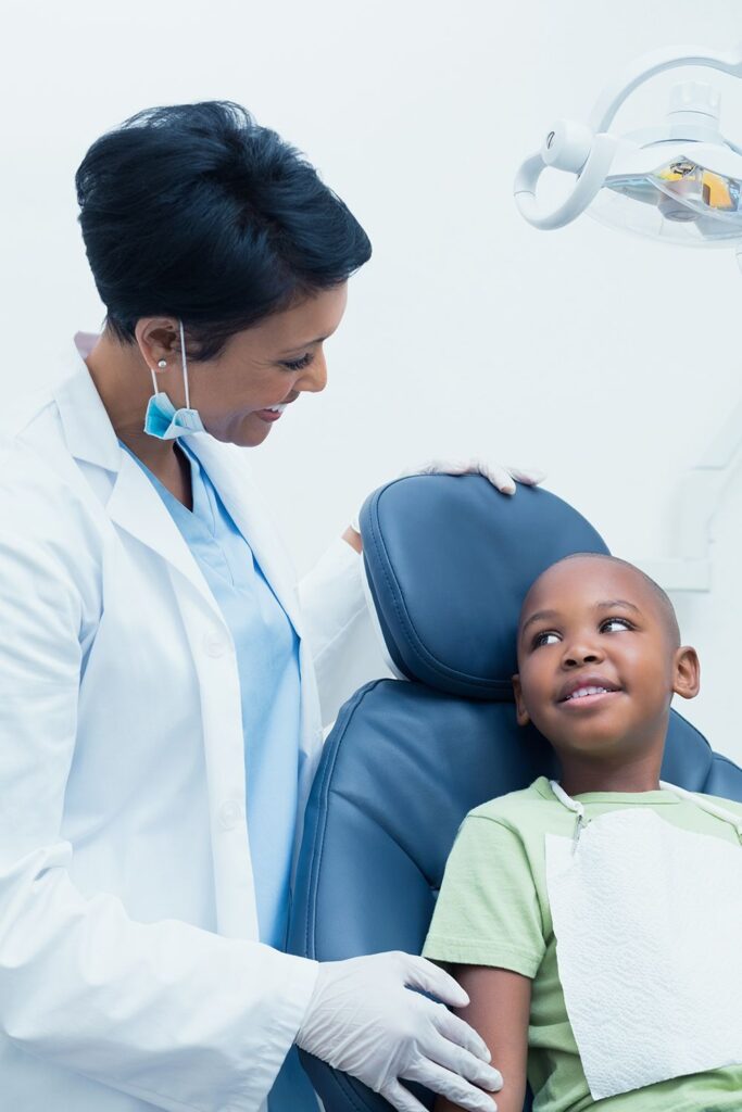 A happy child laughing during a comfortable, stress-free check-up with a pediatric dentist in Abuja.